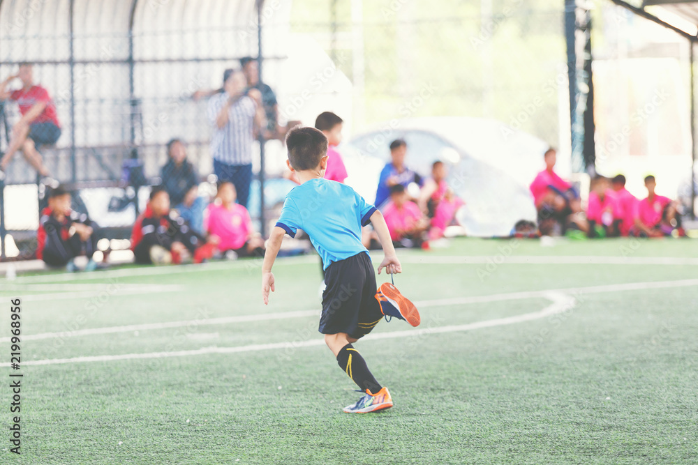 Young Asian football player in blue jersey.