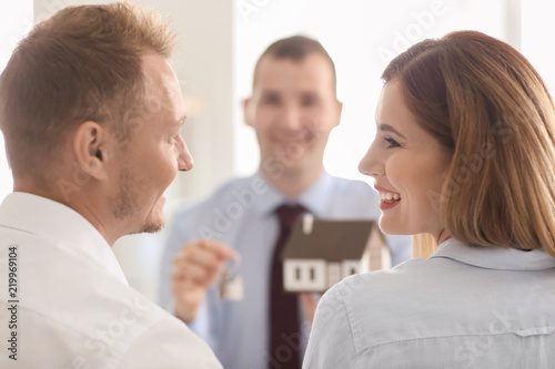 Beautiful couple with real estate agent in office