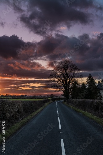 Beautiful sunset and clouds over country road