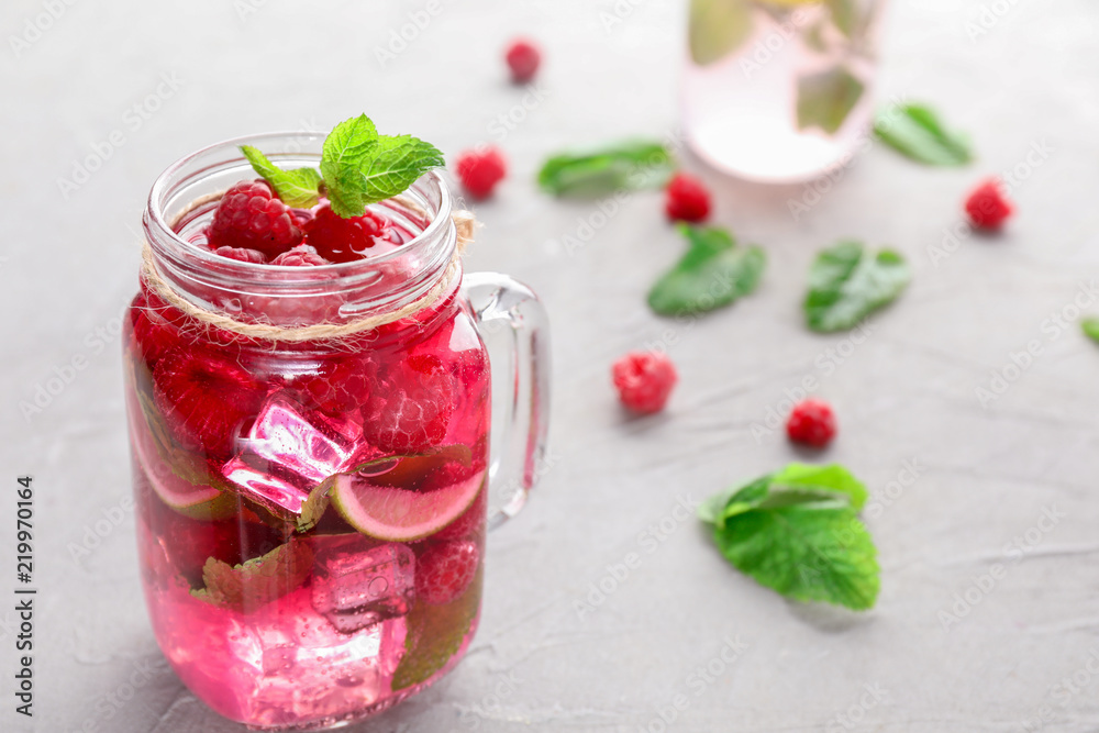 Mason jar of fresh raspberry mojito on light table Mason jar of fresh raspberry mojito on light table