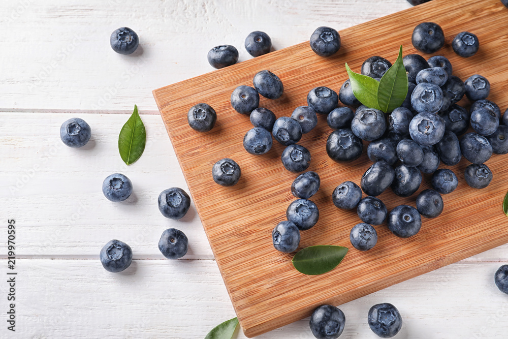 Board with ripe blueberries on wooden table Board with ripe blueberries on wooden table