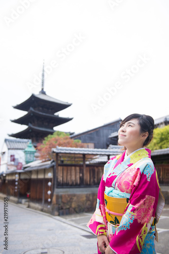 Beautiful Asian woman in Gimono dress is enjoy traveling in Kyoto during winter.