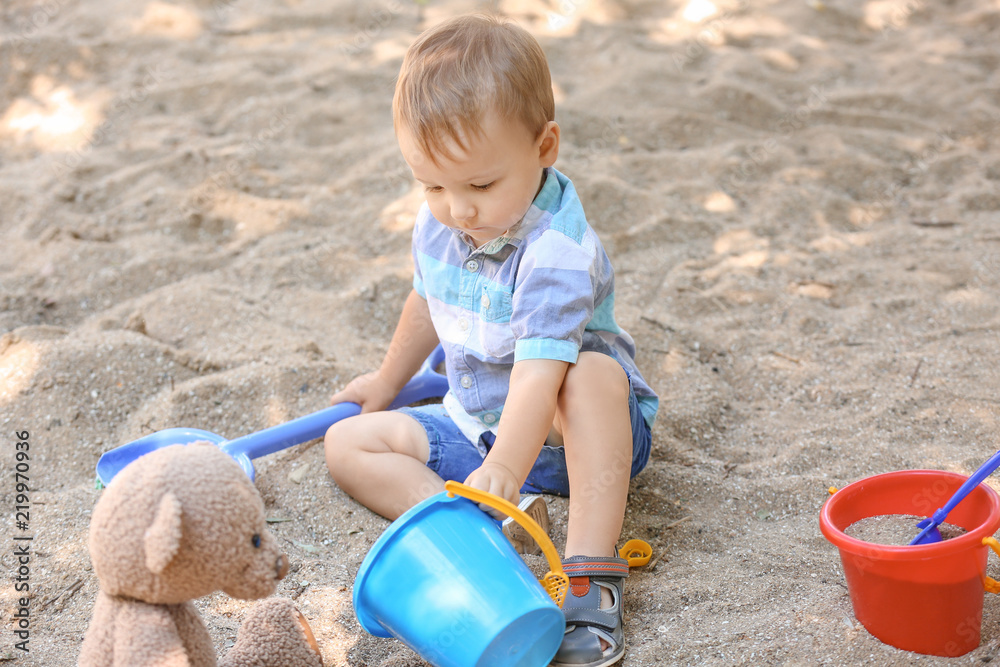 Cute little boy playing in sandbox outdoors Cute little boy playing in sandbox outdoors