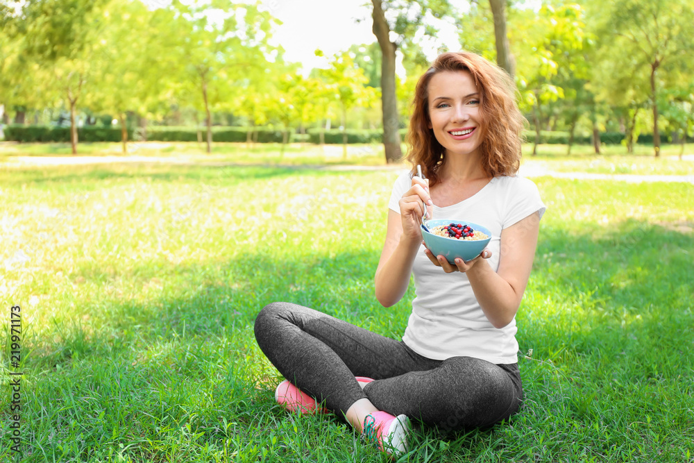 Fototapeta premium Woman eating tasty oatmeal outdoors