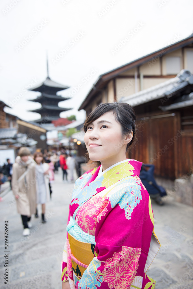 Beautiful Asian woman in Gimono dress is enjoy traveling in Kyoto during winter.