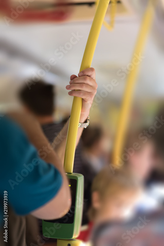 man holding the yellow handrail on train