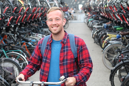 Cute guy in modern bicycle parking lot 