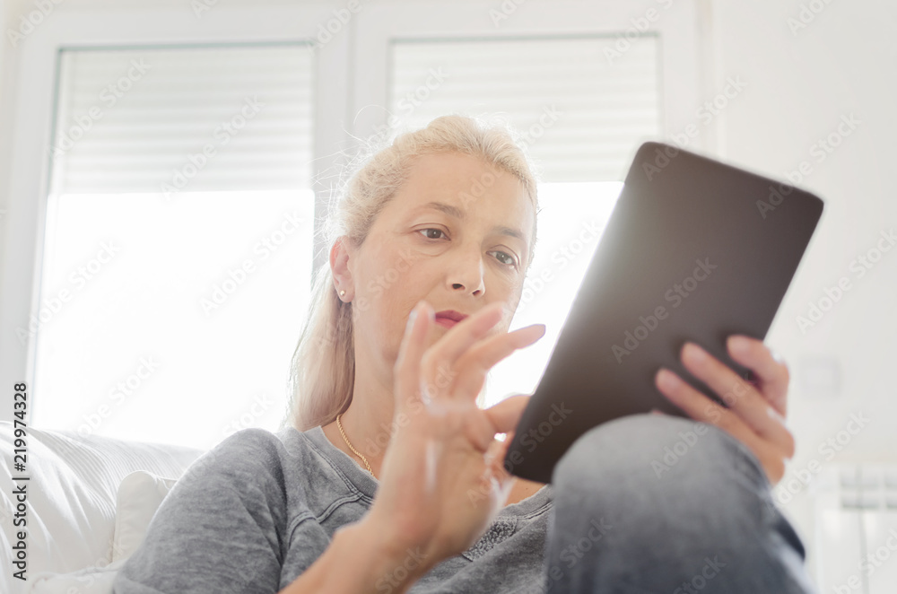 Fototapeta premium Woman texting on tablet