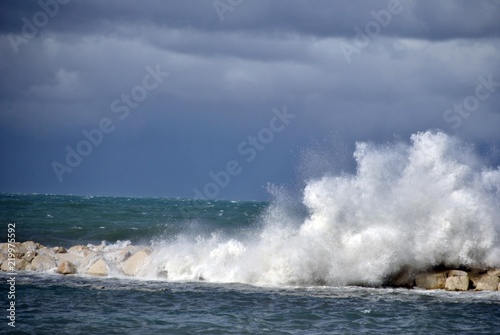 windy day at sea with big waves against rocks