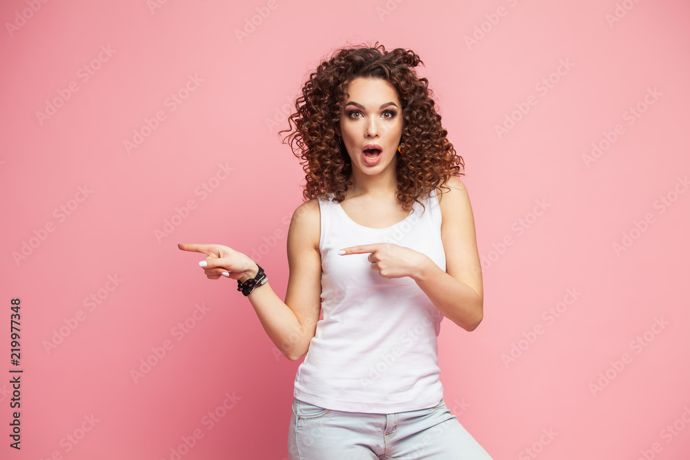 Photo of happy young woman standing isolated over pink wall background. Looking camera showing copyspace pointing. Photo of happy young woman standing isolated over pink wall background. Looking camera showing copyspace pointing.
