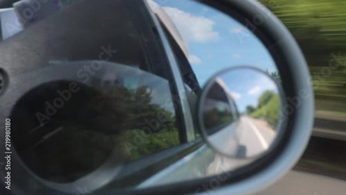 Side mirror rear view scenery in a moving car