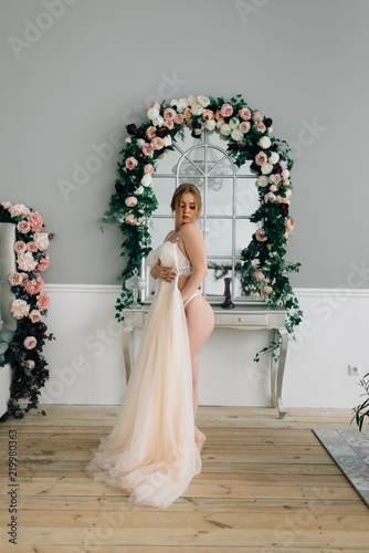 Portrait of curly blonde posing in wedding dress. photo