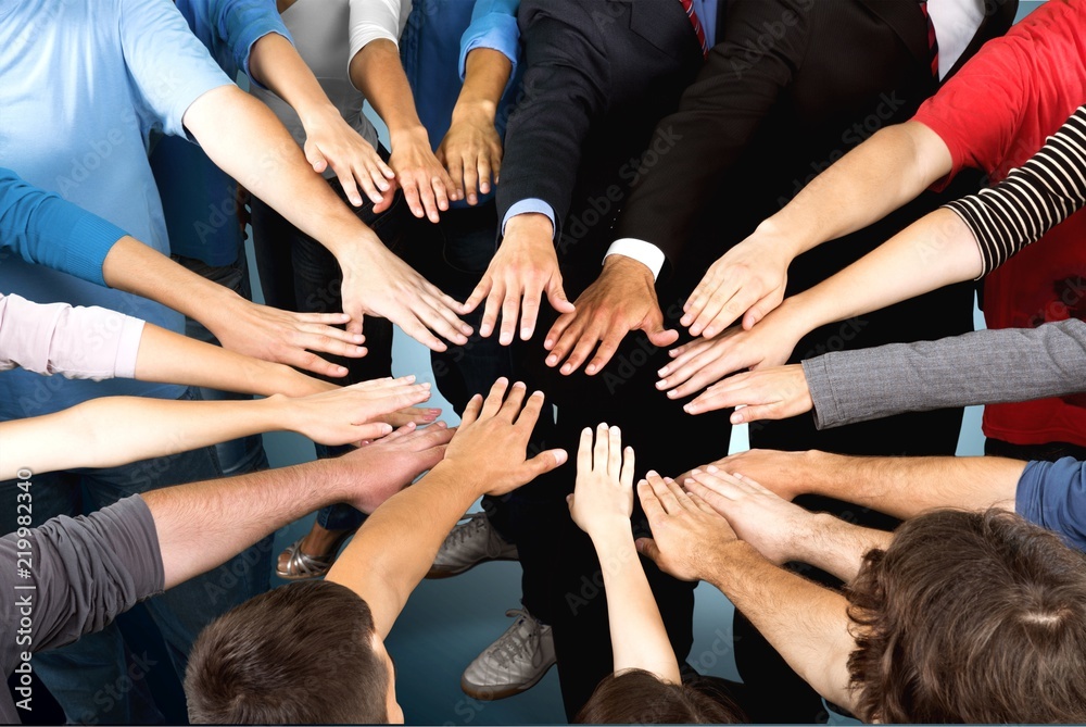 Close-up view of group of people stacking hands Close-up view of group of people stacking hands