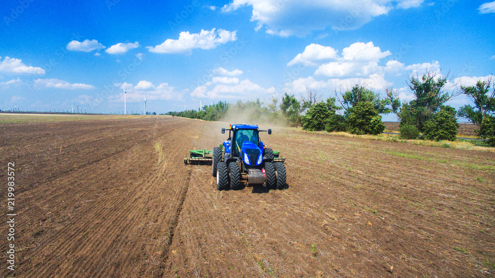 A tractor plowing and sowing in the field A tractor plowing and sowing in the field