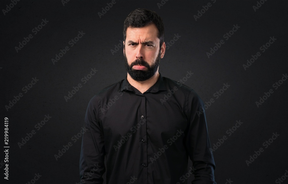 Sad handsome man with beard on black background Sad handsome man with beard on black background