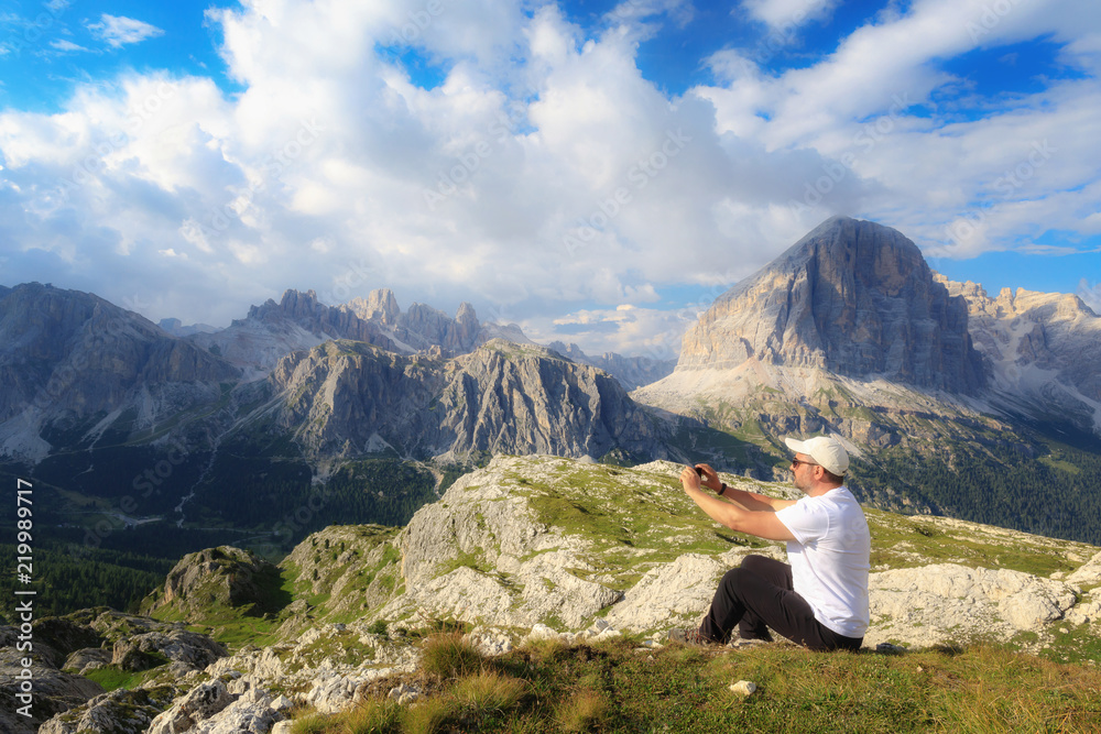 Man takes pictures with his cell phone to the mountain landscape of the Alpine peaks.