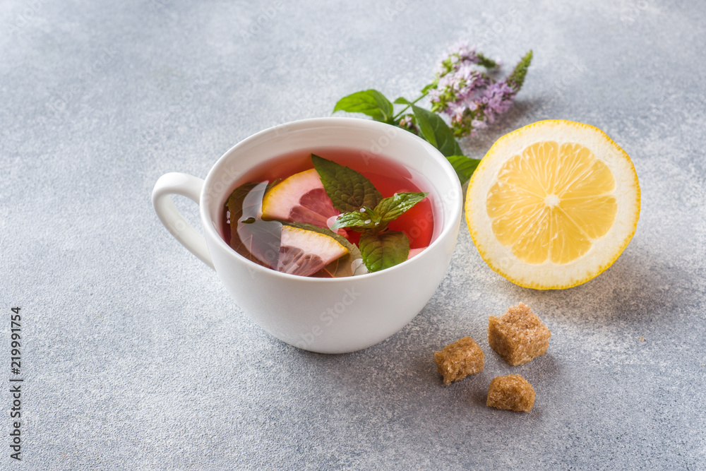 Cup of tea, mint and lemon on grey table with copy space Cup of tea, mint and lemon on grey table with copy space