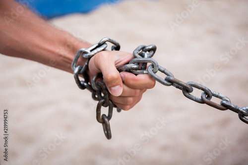 Hand with CHAIN metal and sand desert