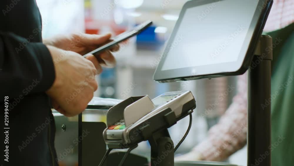 In the Supermarket Close-up Footage of the Man Paying with Smartphone ...