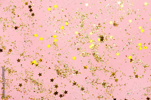 Pink confetti and golden stars and sparkles on pink background. © paninastock