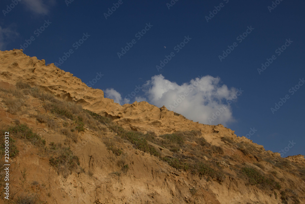 sandy cliffs against the background of a blue picturesque sky with clouds sandy cliffs against the background of a blue picturesque sky with clouds