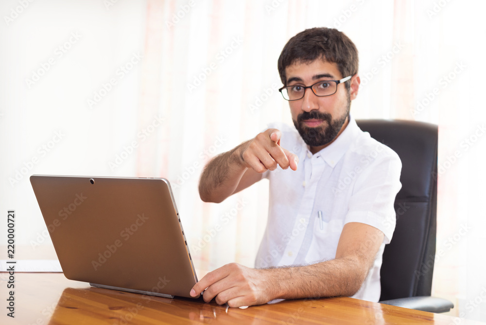 Portrait of a bearded man in the office pointing at you Portrait of a bearded man in the office pointing at you