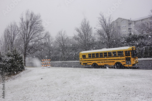 School bus on road during the snow storm or blizzard. Abstract concept.