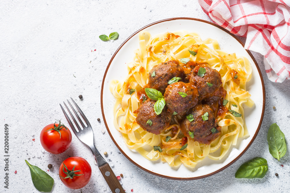 Naklejka premium Meatballs in tomato sauce with pasta tagliatelle top view.