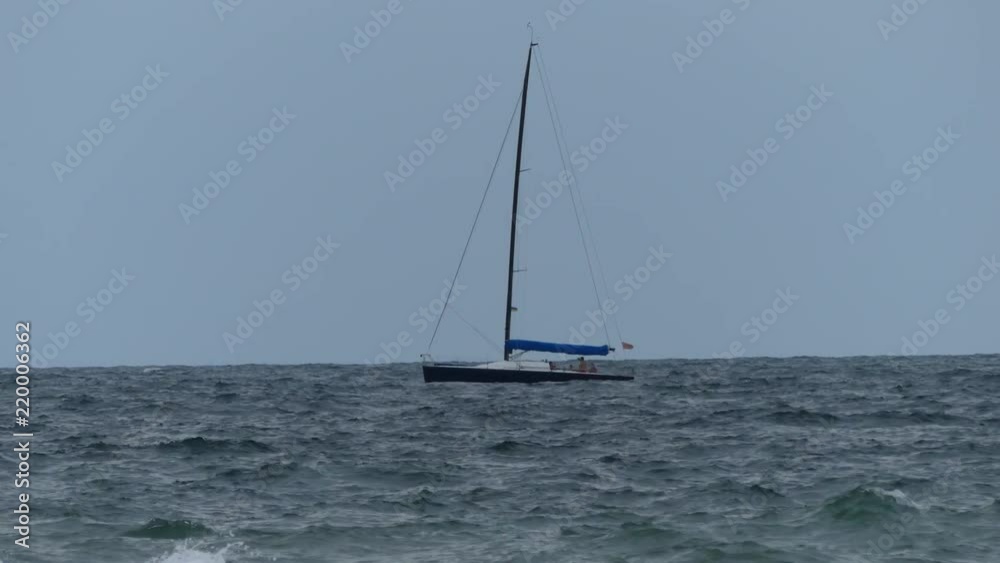 Odessa, Ukraine - July 25, 2018: A yacht floating across the Black Sea. The yacht floats along the waves. Odessa, Ukraine - July 25, 2018: A yacht floating across the Black Sea. The yacht floats along the waves.