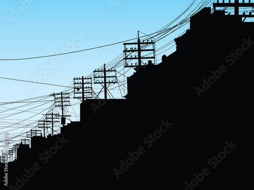 Silhouette of College Street in Toronto showing electrical poles and wires in a thick tangle.