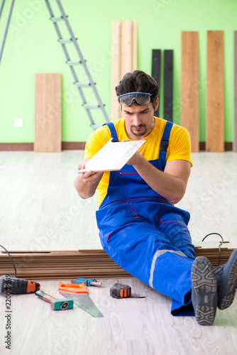 Professional contractor laying flooring at home