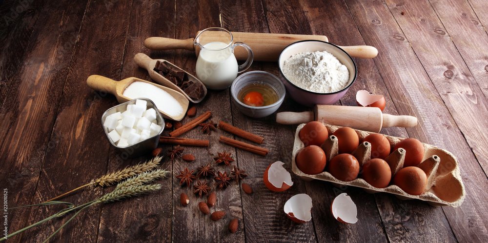 Bakery ingredients - flour, eggs, butter, sugar, yolk, almond nuts on blue table. Sweet pastry baking concept. Bakery ingredients - flour, eggs, butter, sugar, yolk, almond nuts on blue table. Sweet pastry baking concept.