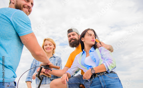 Cycling modernity and national culture. Group friends hang out with bicycle. Company stylish young people spend leisure outdoors sky background. Couple meet cheerful friends with bicycle during walk