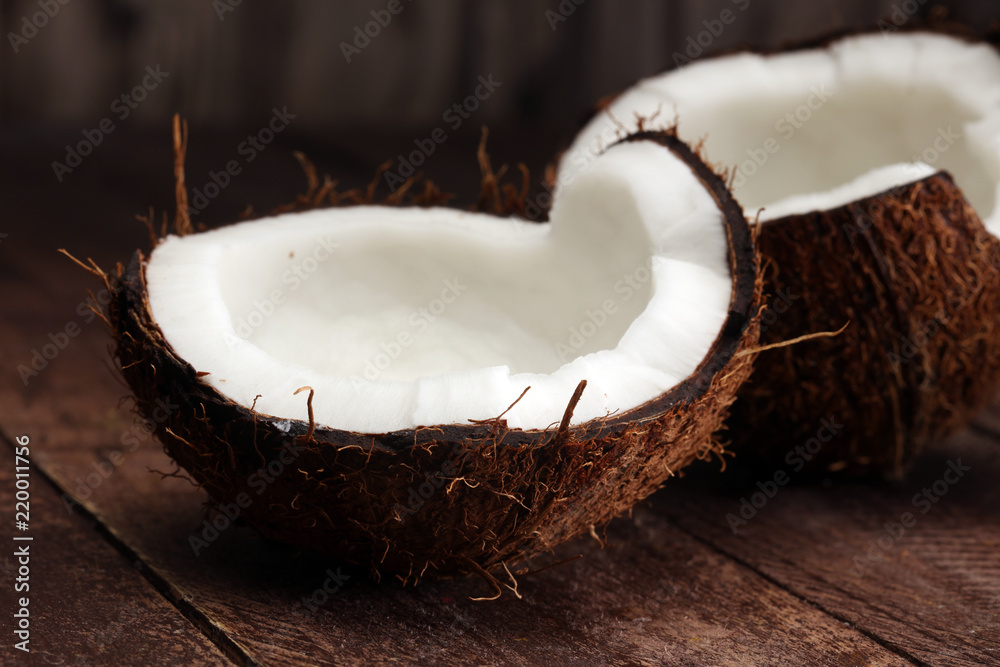 Ripe half cut coconut on a wooden background. Ripe half cut coconut on a wooden background.