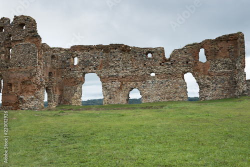Fragment of a ruined stone wall with an arch and windows