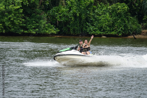 Happy young couple with thumbs up enjoying and having fun riding on a jet ski. Tropical coast of Sri Lanka