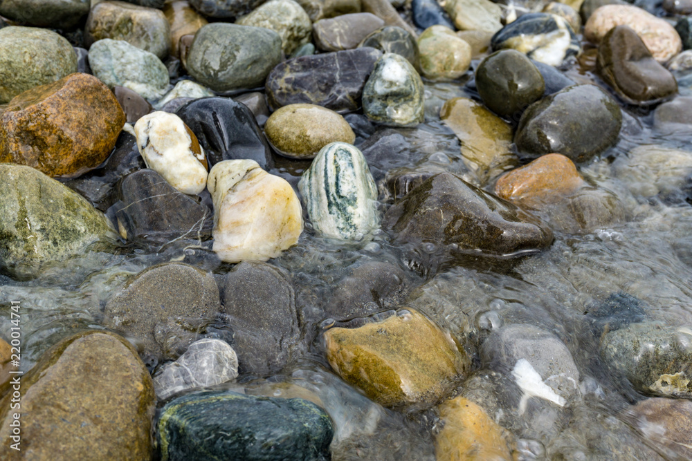 Bunte große Kieselsteine im Wasser. Bunte Strandsteine im Bodensee