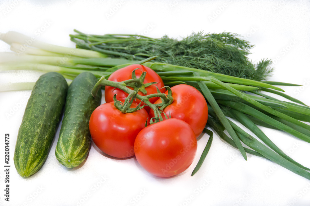 Tomatoes on a branch and cucumbers and greens isolated on white background. Vegetables on a white background. Food . Healthy eating. Tomatoes on a branch and cucumbers and greens isolated on white background. Vegetables on a white background. Food . Healthy eating.