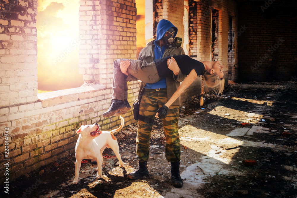 surviving man in a gas mask holding a dead girl in the background of the ruins after the Apocalypse war. surviving man in a gas mask holding a dead girl in the background of the ruins after the Apocalypse war.