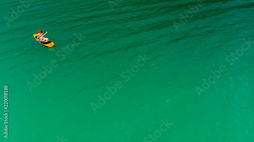 un fond d'eau verte avec une personne sur un paddle dans le coin