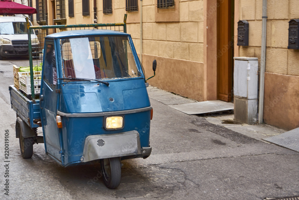 Blue Piaggio Ape Driving Through Old Italian Town
