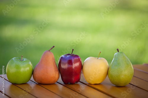 Apples and Pears lined up in a row on table