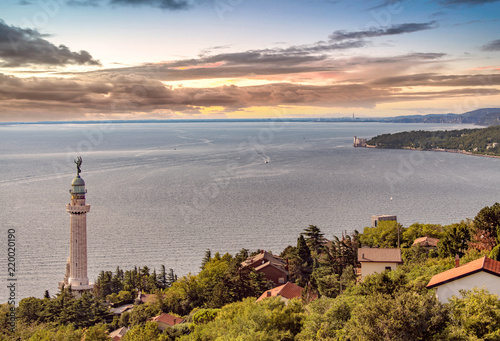 Il golfo di Trieste, con il Faro della Vittoria e il Castello di Miramare durante un tramonto