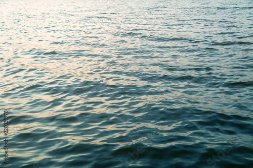 Dark blue water surface with sunset light redlection. Sea or ocean water background
