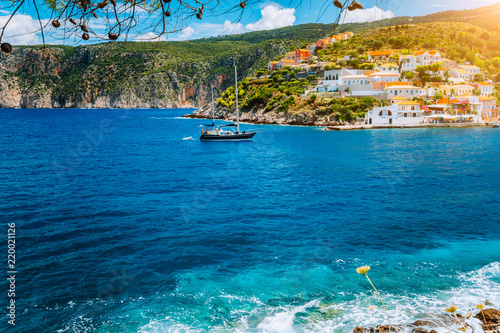 Yacht arrived in beautiful Assos village located on Kefalonia with clear blue sea water on summer vacation trip around Greece photo
