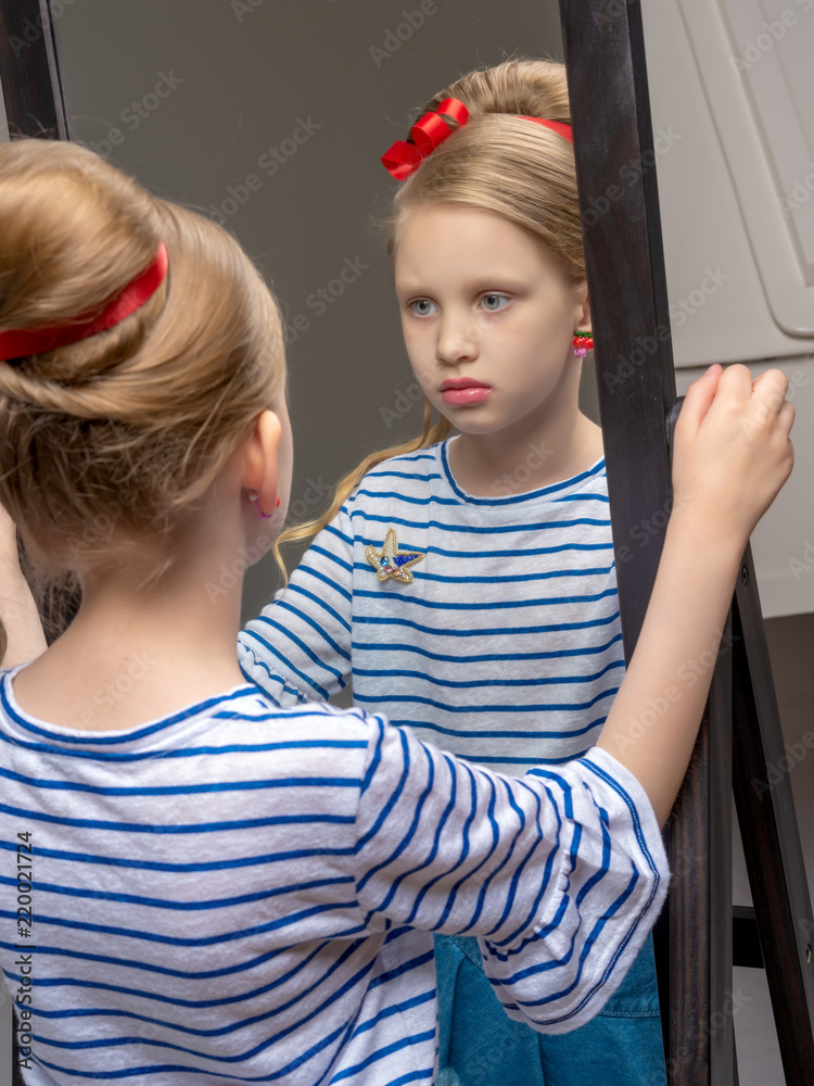 A little girl near the mirror paints lipstick lips A little girl near the mirror paints lipstick lips