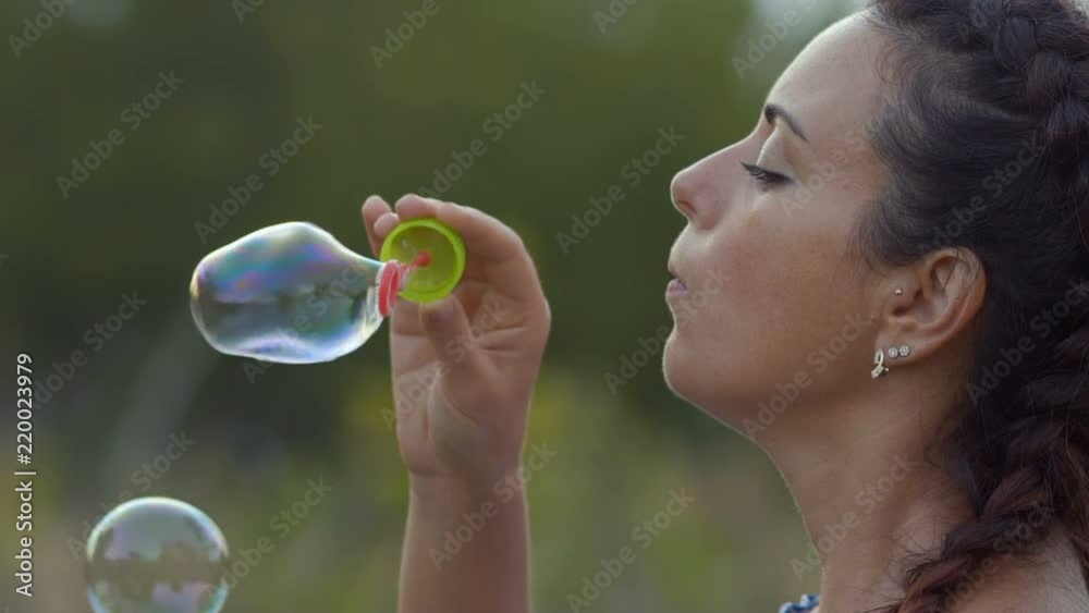 Slow Motion, Close-up Beautiful Woman Puffs Soap Bubble Slow Motion, Close-up Beautiful Woman Puffs Soap Bubble