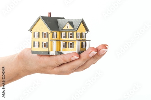 Women's Hand Holding a Model of a House