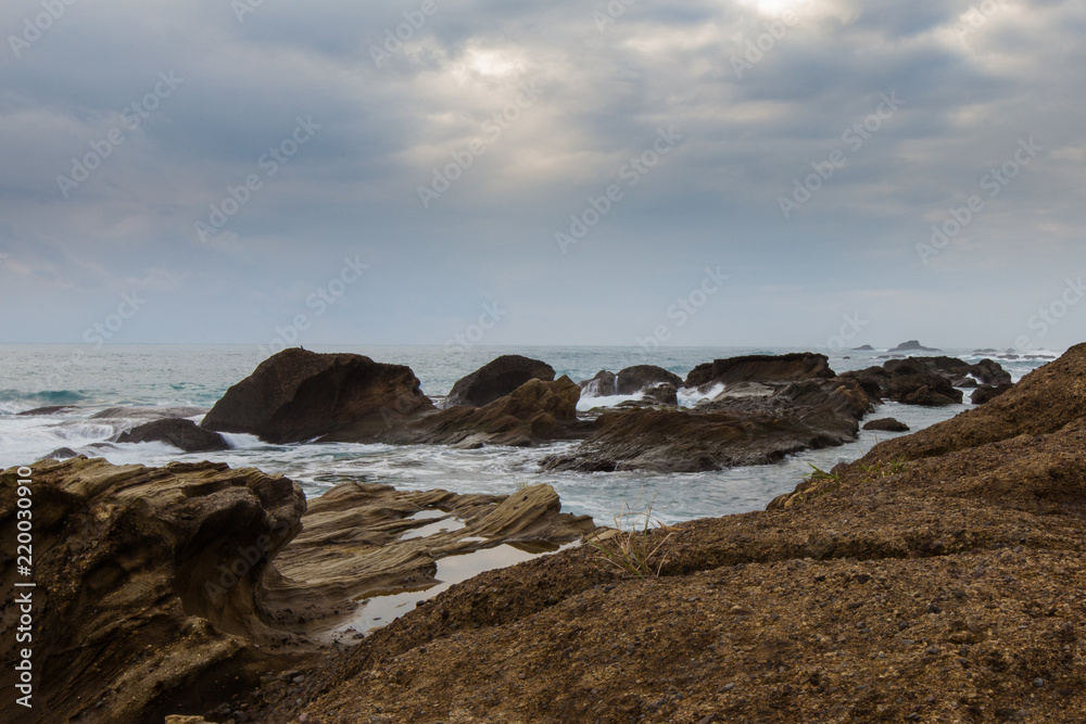 Taiwan East Coast Rocky Coastline Background Image - Overcast Skies, Exotic Rock Formations, Waves in the Ocean. Ocean Coastline, Asia Landscape Photography, Clouds reflection in background