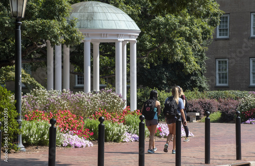 A small group of students walk past the Old Well at UNC Chapel Hill photo